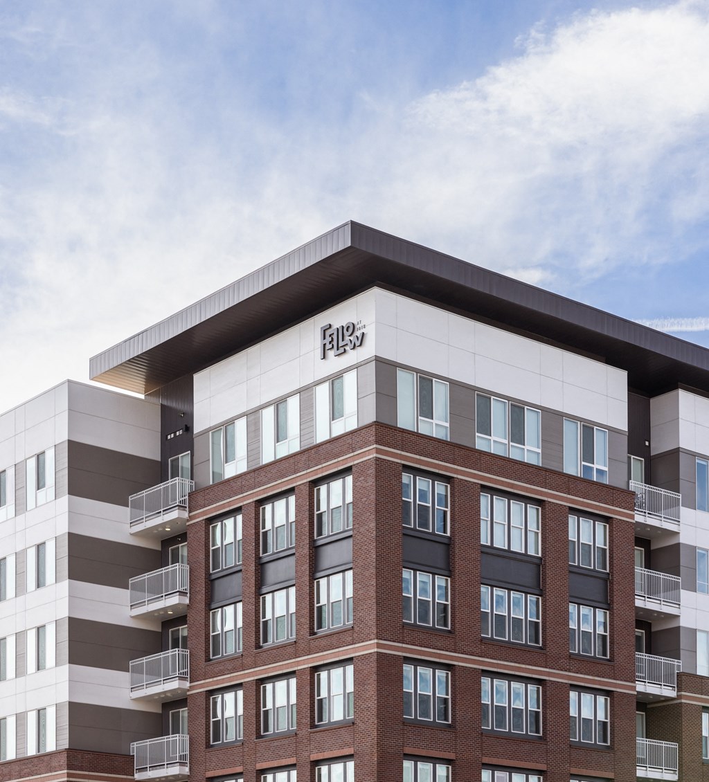 A tall building with a flat roof and balconies on the second floor.