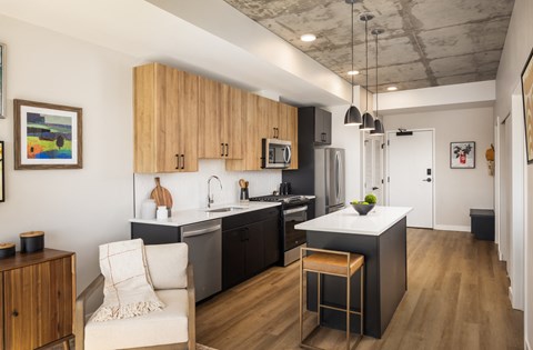 A kitchen with a white chair and a bar stool.