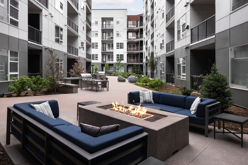 A patio with a fire pit and seating area.