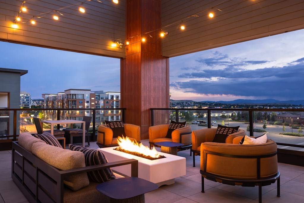 A patio with a fire pit and seating area.