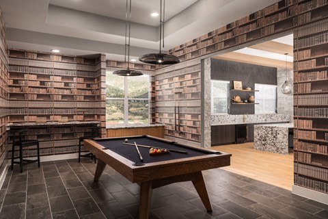 A pool table is in the middle of a room with brick walls.