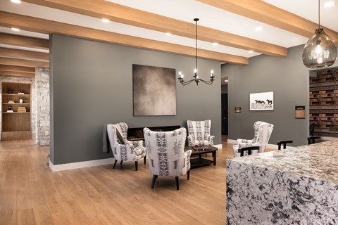A living room with a grey wall and a large painting hanging on it.