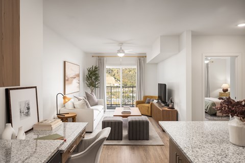 A modern living room with a large window and a balcony.