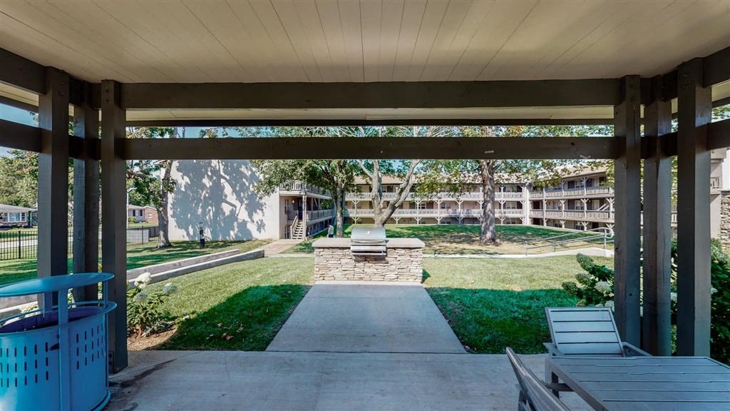 a covered walkway leading to a fire pit in front of a building