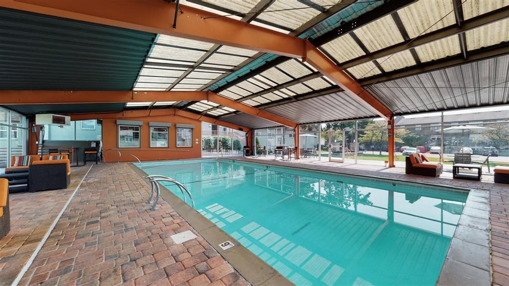 a swimming pool with a ceiling and brick floor