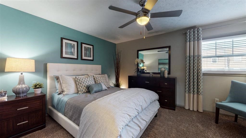a bedroom with a large bed and a ceiling fan