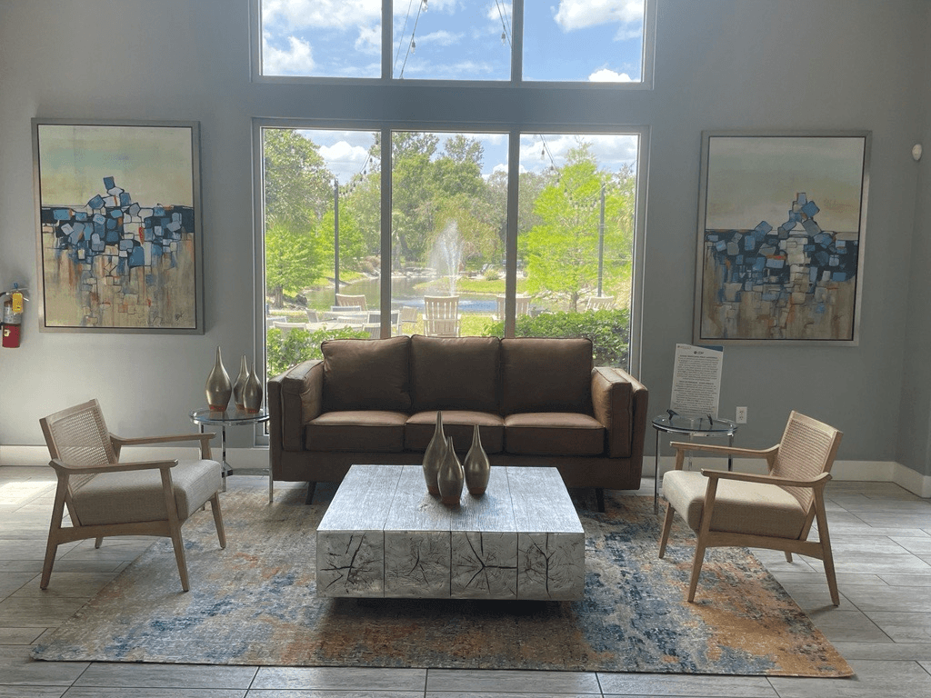 a living room with a couch and chairs in front of a large window