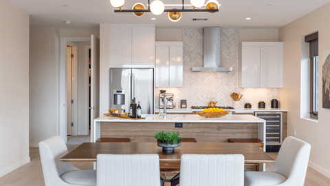 A modern kitchen with a dining table and chairs.