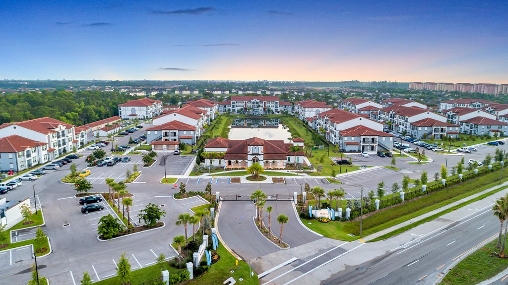 A large, well-maintained housing complex with a spacious parking lot.