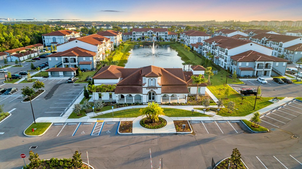 A sunny day at a residential complex with a large parking lot.