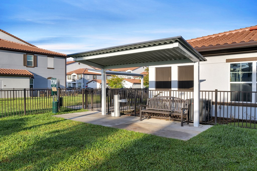 A patio with a table and chairs is covered by a roof.