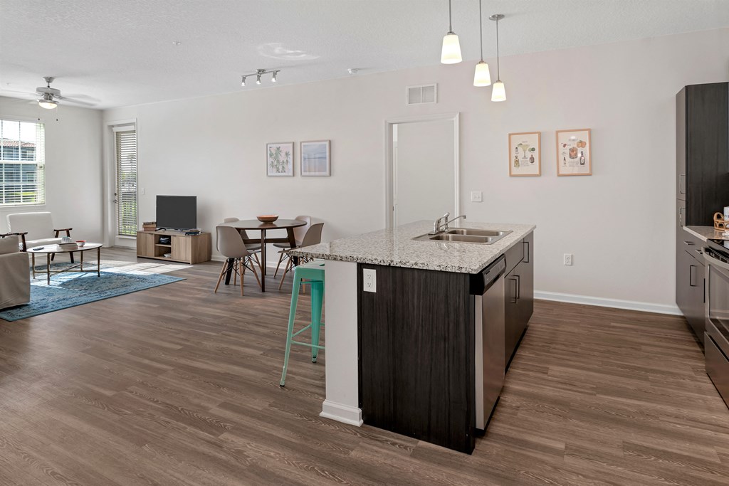 A kitchen with a sink, stove, and refrigerator.