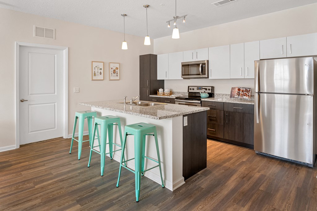 A kitchen with a bar area and a refrigerator.