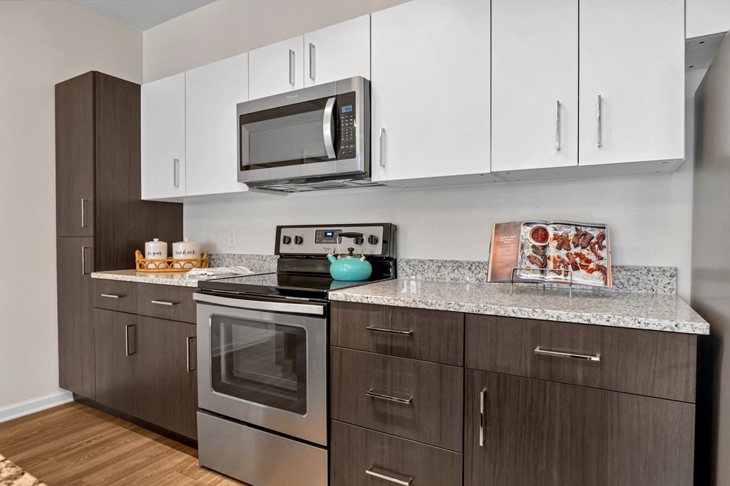 A kitchen with a stainless steel oven and microwave.