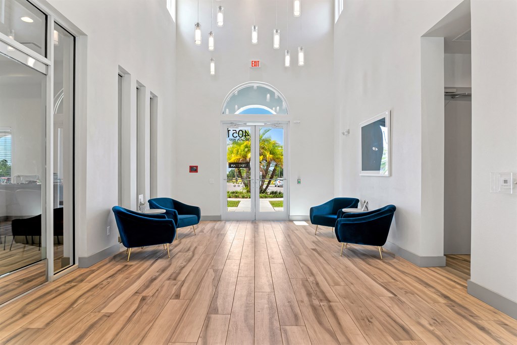 A hallway with two chairs and a table in the middle.
