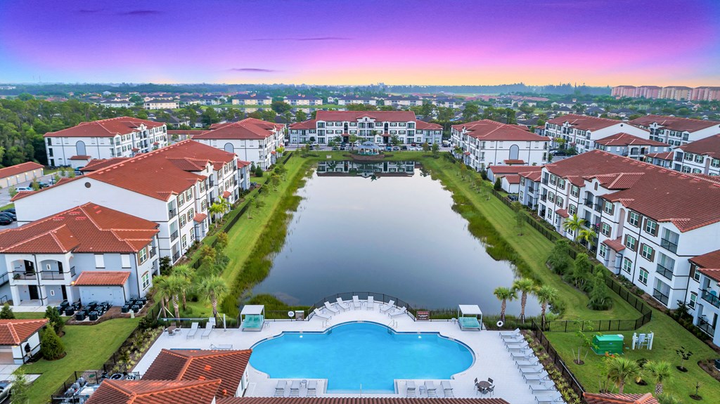 A large swimming pool is surrounded by apartment buildings.