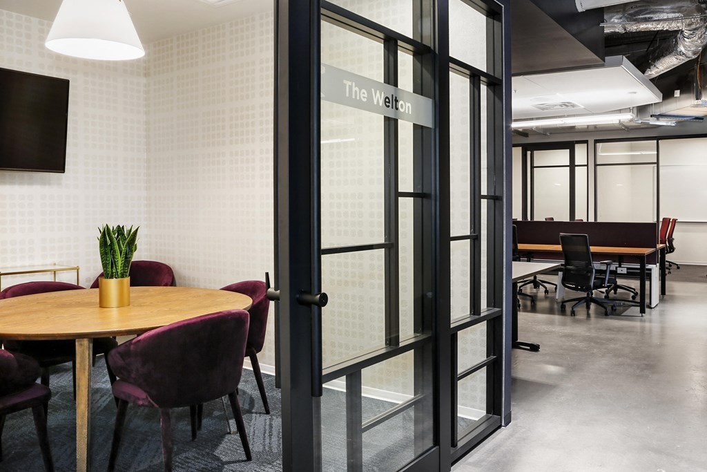 a conference room with glass doors and a table with chairs