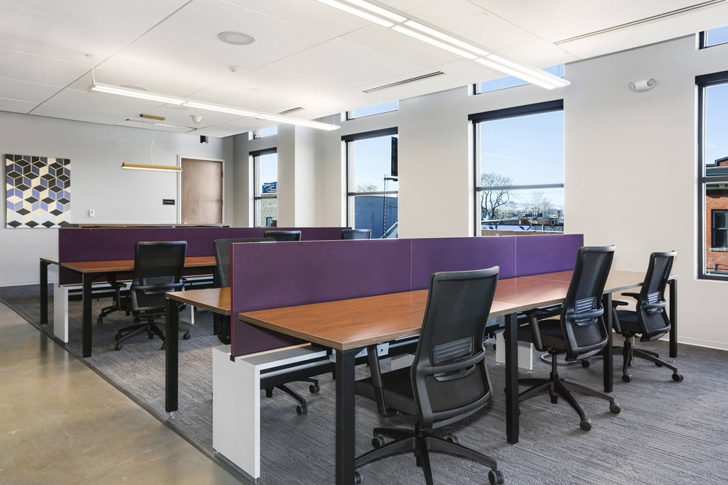 a large meeting room with tables and chairs and a purple divider