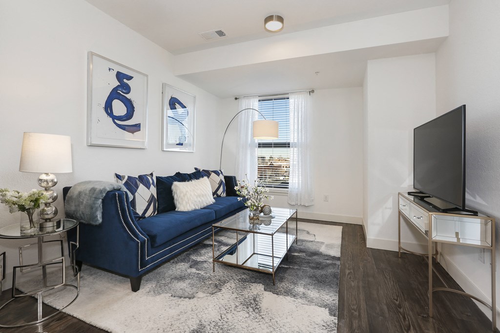 a living room with a blue couch and a tv