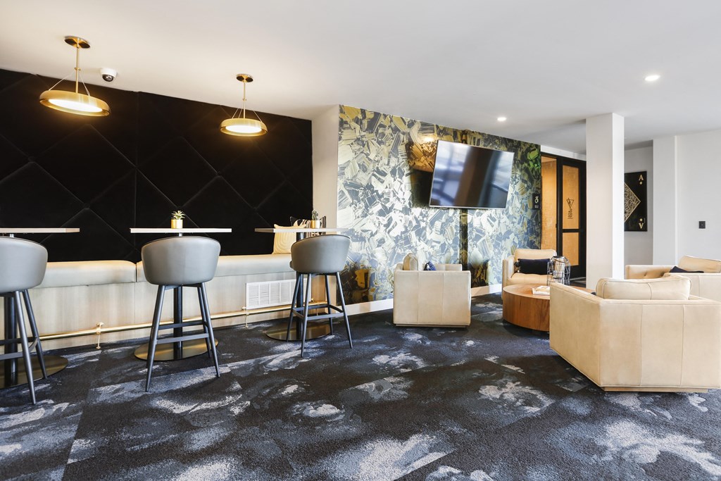 a living room with couches and a bar and a television