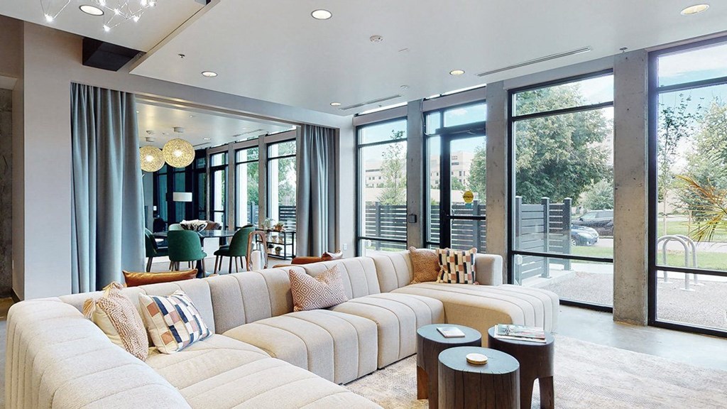 a living room with a long white couch and a large window