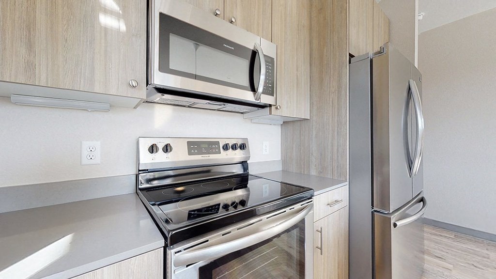 a kitchen with wood cabinets and stainless steel appliances