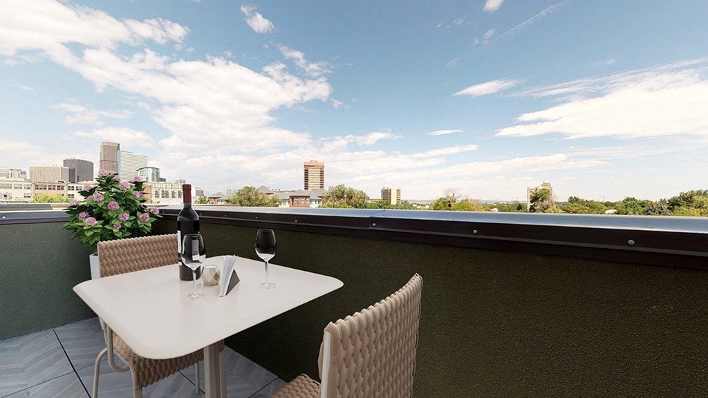 a balcony with a table and chairs and a bottle of wine on it