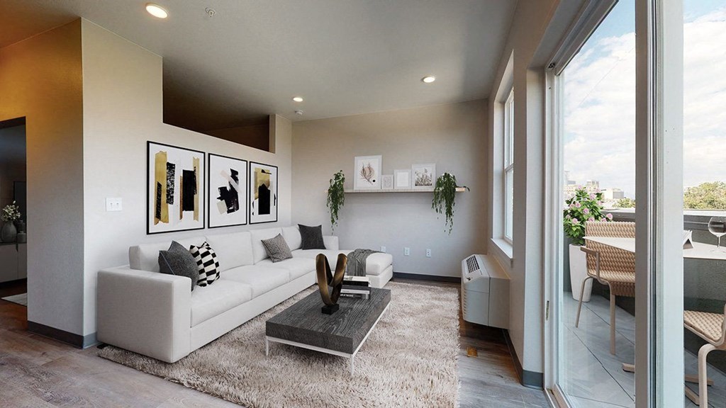 a living room with a white couch and a coffee table in front of a sliding glass door