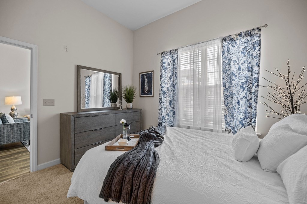 a bedroom with a large bed and a window with curtains