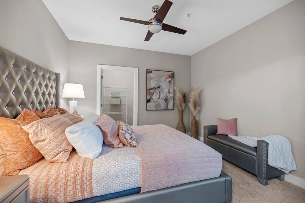 a bedroom with a large bed and a ceiling fan