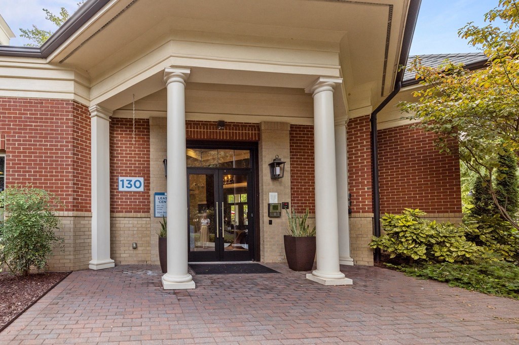 the front of a brick building with pillars and a door