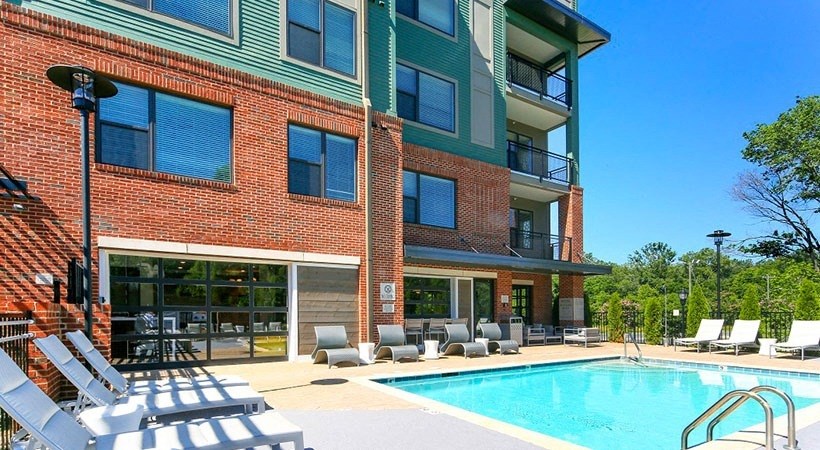 a swimming pool in front of a brick building