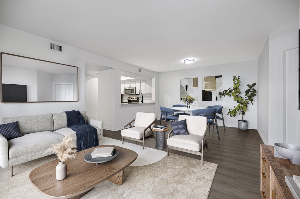 a living room with white walls and a large mirror on the wall