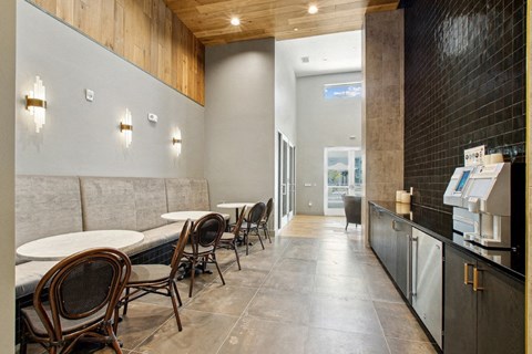 A restaurant with a long table and chairs on the left side and a counter on the right side.