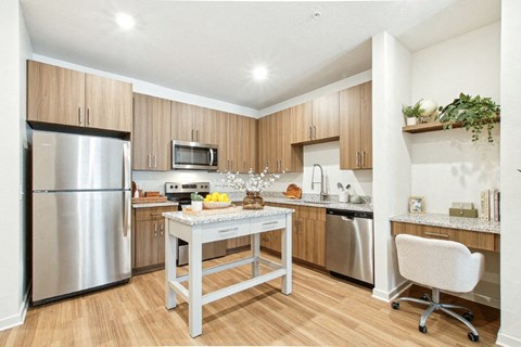 A kitchen with a stainless steel refrigerator, microwave, and dishwasher.
