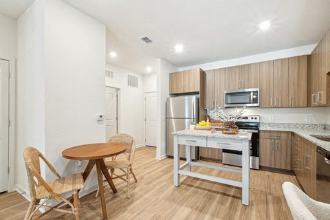 A kitchen with a table and chairs.