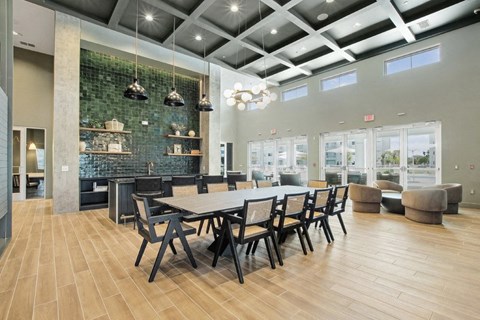 A modern dining room with a long table and chairs.