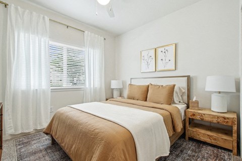 A bedroom with a large bed and a wooden nightstand.