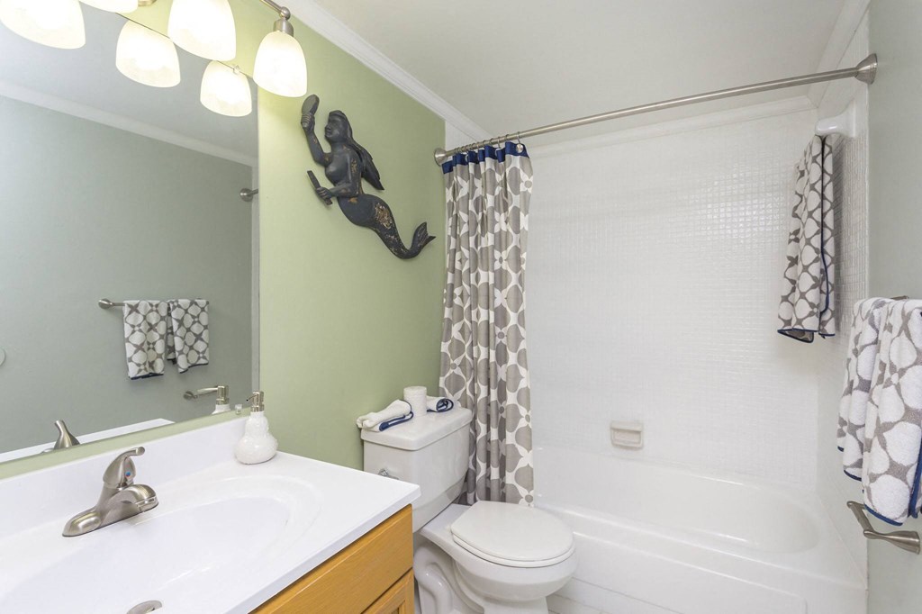 a bathroom with green walls and a white bathtub
