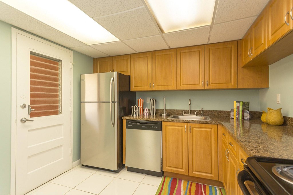 a kitchen with wooden cabinets and a stainless steel refrigerator