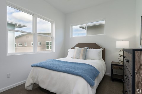 A bedroom with a large bed and a window overlooking a building.