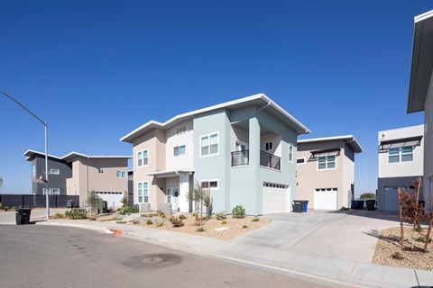 A row of modern houses with garages and driveways.
