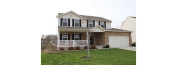 A house with a white porch and a brown roof.