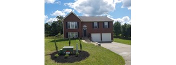 A house with a grey roof and a white garage door.