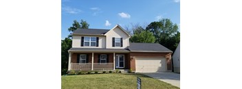 A house with a white garage door and a brown brick chimney.