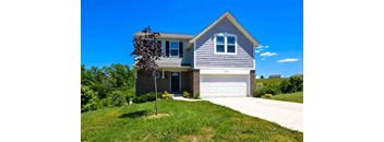 A house with a grey roof and a white garage door.