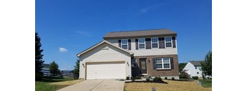 A two-story house with a garage and a driveway.
