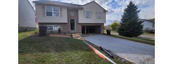 A house with a grey front yard and a driveway.