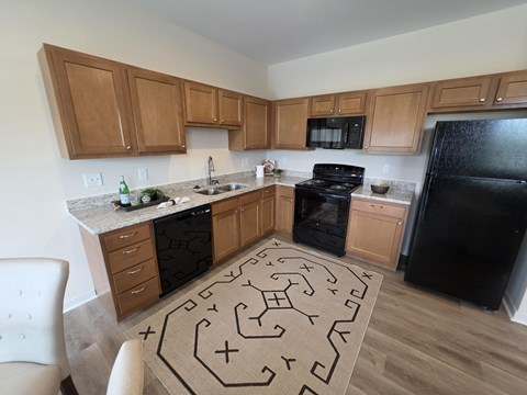 A kitchen with wooden cabinets and black appliances.