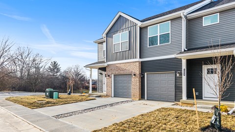 A modern two-story house with a grey exterior and a grey garage door.